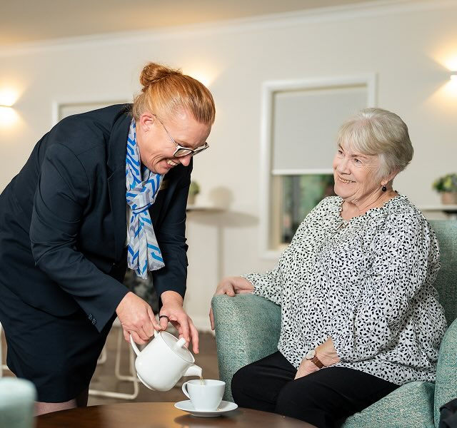 Allan Drew funeral director serving tea to a woman