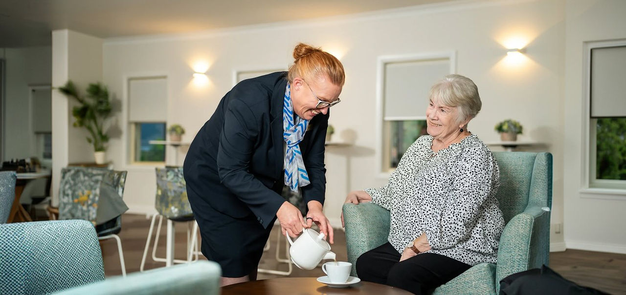 Allan Drew funeral director serving tea to a woman