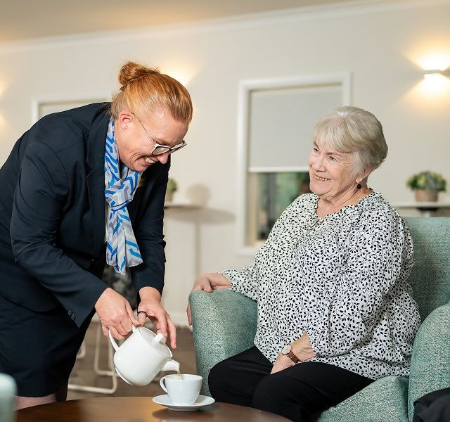Allan Drew funeral director serving tea to a woman