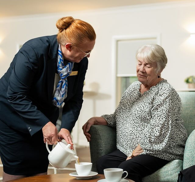 Allan Drew funeral director serving tea to a woman