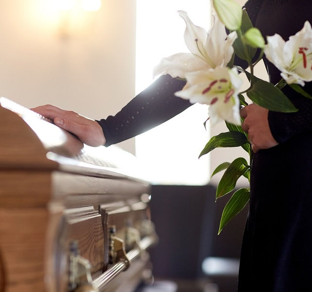 a woman touching a coffin