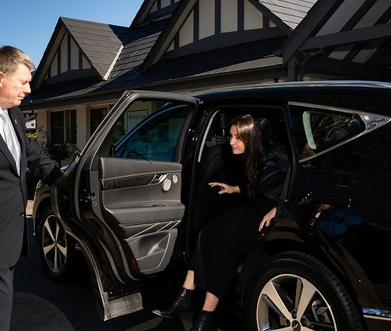 Allan Drew funeral director opening a hearse door for a passenger