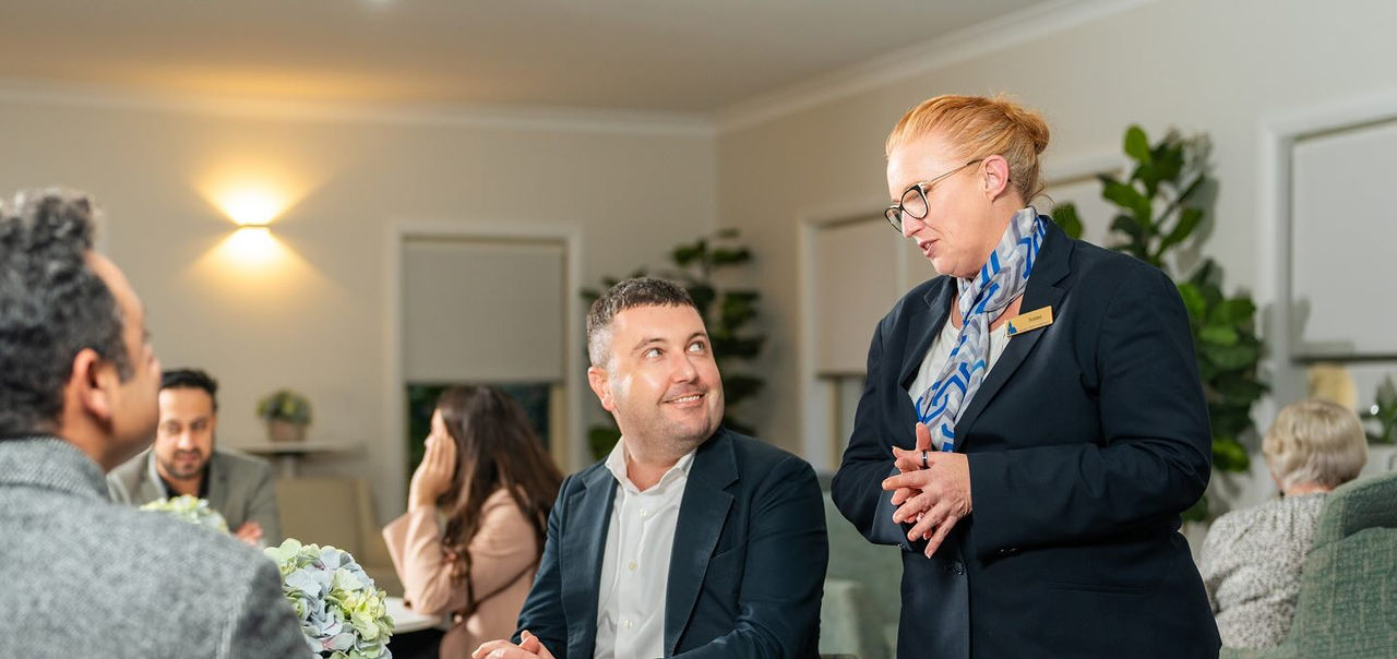 Allan Drew funeral director with people at a reception