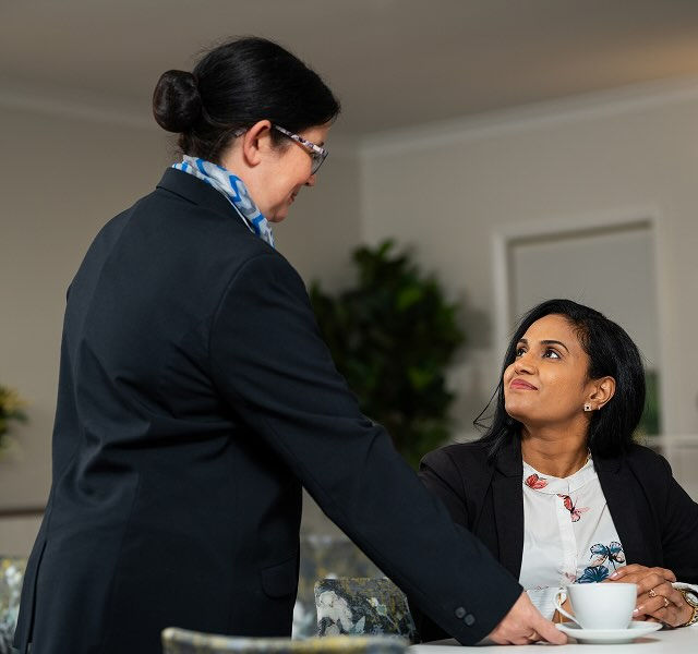 Allan Drew funeral director serving tea to a woman