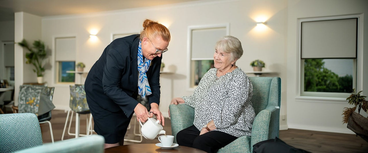 Allan Drew funeral director serving tea to a woman